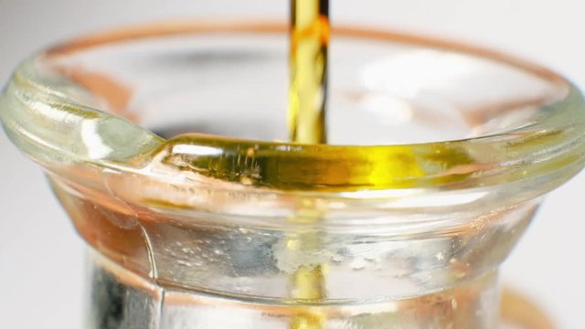 Filling up a glass serving bottle with golden high quality olive oil