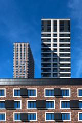 Fototapeta premium Abstract geometric citiscape with high-rise buildings on a blue sky background
