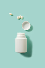 Unmarked white container with pills on a blue background - concept for healthcare