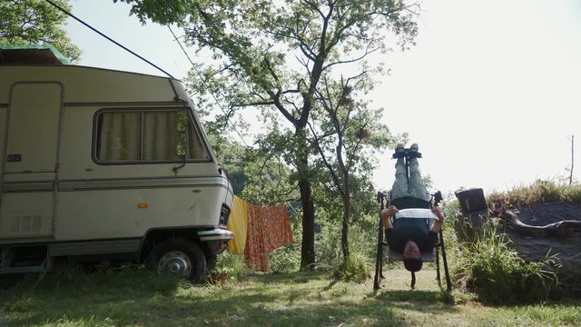 Man doing exercise on inversion table in camp to relax, improve overall posture