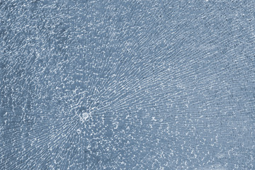 The texture of cracked glass after being shot with a traumatic gun