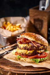 Juicy American burger, hamburger or cheeseburger with two beef patties, with sauce and basked on a...