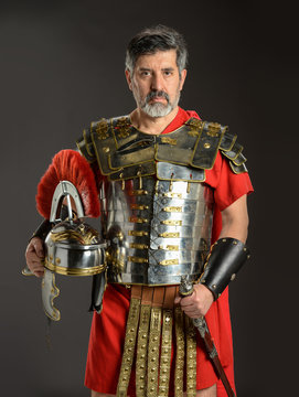 Roman soldier posing holding his helmet