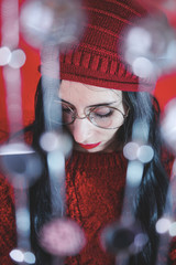 Studio artistic portrait of a brunette woman against red  background