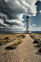 Lighthouse on the Formentera island, Spain, the blue sky with white clouds, without people, rocks, stones, sunny weather