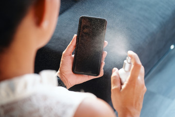 Woman Cleaning And Disinfecting Cell Phone Against Virus