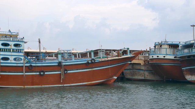 Tracking shot of Iranian launch Lenj fishing boats in a harbour in the strait of Hormuz