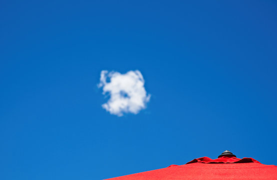 red umbrella with blue sky and white cloud