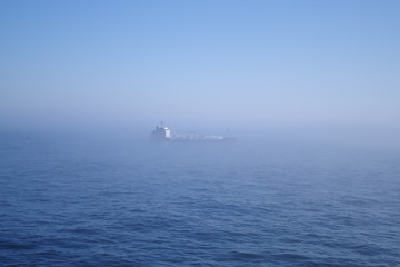 Obraz premium Ship sailing in fog at sea