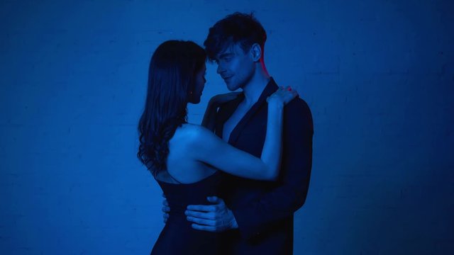 attractive woman touching man in blazer on blue
