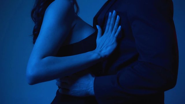 passionate woman touching man in blazer on blue