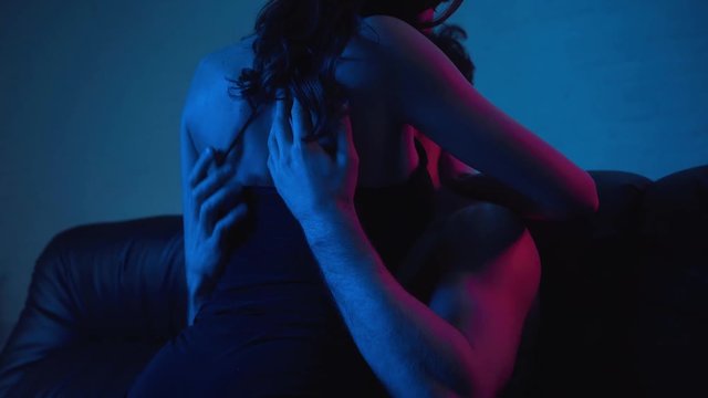 shirtless man kissing with girlfriend on blue
