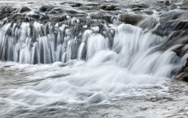 Fototapeta na wymiar Water flows on a cascade in nature