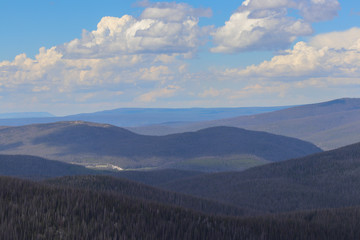  Colorado mountain peaks with blue cloudy skies above 