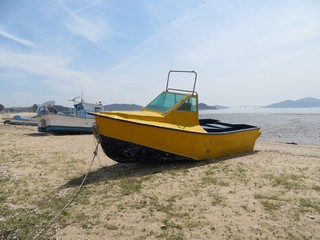 Naklejka na ściany i meble Eclectic yellow motorboat on a sandy beach in Incheon, Korea