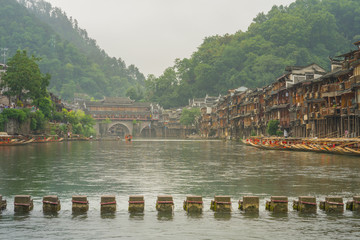 Signature view of ancient stone bridge at Fenghuang or Phoenix town. This ancient town is world heritage site of UNESCO. The excited activity to walk over the bridge for cross Tuojiang river.