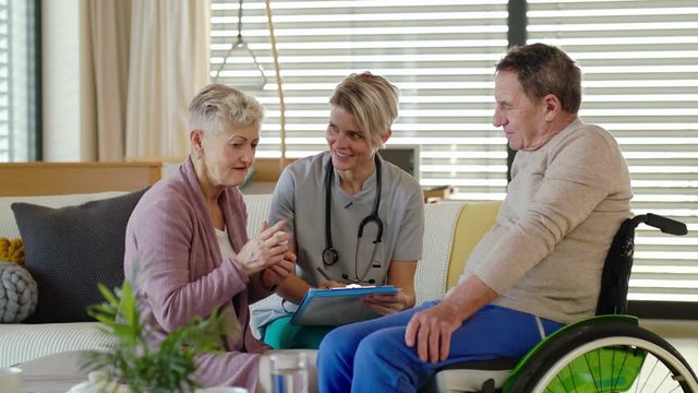 Healthcare worker visiting senior patient in wheelchair at home.