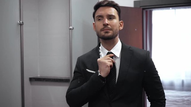 focus pull of businessman looking at mirror in bathroom