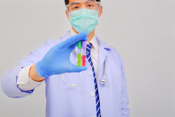 Fototapeta premium Medical doctor in white uniform doctor wears medical gloves, medical masks and and wearing protective glasses holding vaccine vial on gray background, corona virus concept, medical concept