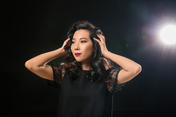 Young Asian woman with beautiful hair on dark background