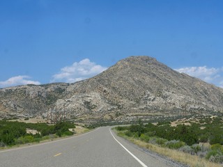 Scenic landscape witha bare rock mountain along the road at the Wyoming-Montana border.