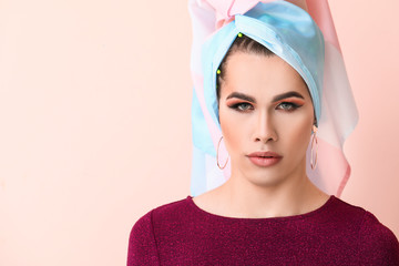 Portrait of young transgender woman on color background