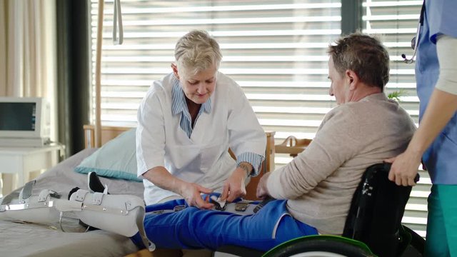 Healthcare workers and paralysed senior patient in hospital, applying orthosis.