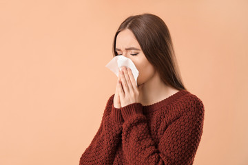 Sick young woman on color background