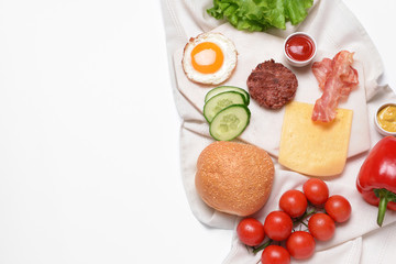 Ingredients for tasty burger on white background