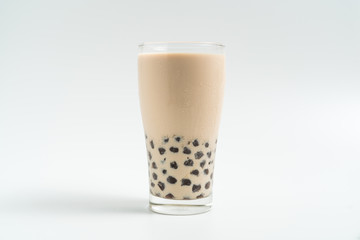 A glass cup of pearl milk tea (also called bubble tea) and a plate of tapioca ball on white background. Pearl milk tea is the most representative drink in Taiwan. Taiwan food . With copy space.