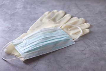 Medical mask and latex gloves on a concrete background