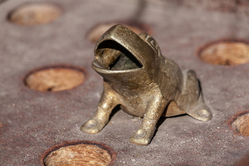 Closeup of a metal frog, part of the game Toad in the hole or frog game (Sapo), a traditional game in South America