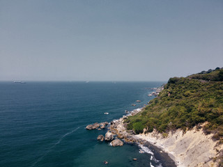 Fototapeta na wymiar aerial view of ocean, a narrow beach and a mountain