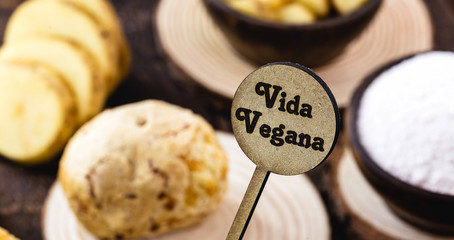 small wooden sign with inscription: Vegan life, with rustic wooden background. Concept of: Healthy...