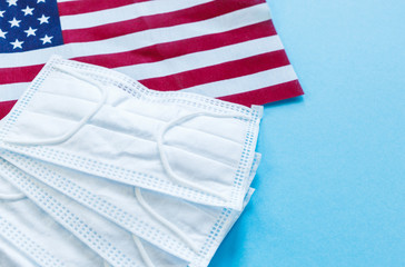 Medical masks with flag of USA on blue background. Mask for protection from dust, pollution, viruses. Flat lay, top view, mock up.