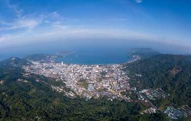 Obraz premium Ultra wide panorama of Patong, Phuket. Aerial view of the sea bay and the city surrounded by mountains
