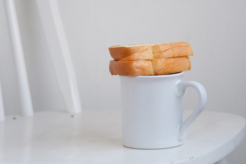 cup of coffee and bread on wood counter background and space for text