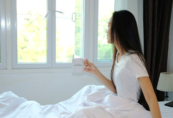 woman drink a cup of coffee in bedroom