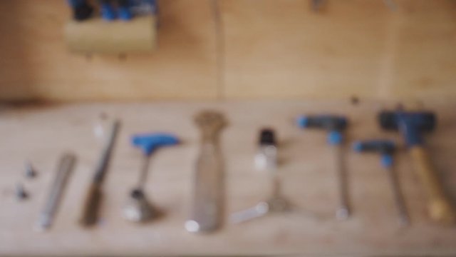 Close up of carpentry tools on workbench in workshop pulled into focus