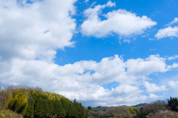 【写真素材】 青空　山と家　雲　春の空　民家　背景　背景素材　3月　コピースペース