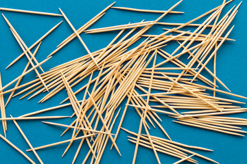 Lots of wooden toothpicks on a blue background. The concept of order and chaos.