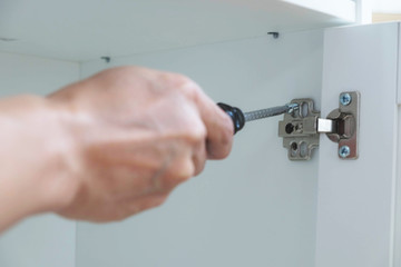 The mechanic assembled the furniture in the house according to the manual, along with the mechanic equipment. By hammering the nails Measuring with a tape measure Screwing the screw Drilling holes.