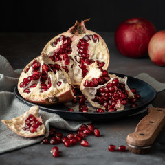 Torn pomegranate fruit on a dark background.