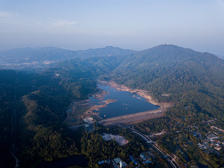 Fototapeta premium A dry dam due to the lack of rain in Thailand. Beautiful lake at sunrise located between the hills and golf courses