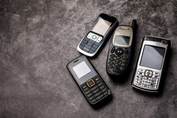 Many obsoleted cellphones on a grunge background.