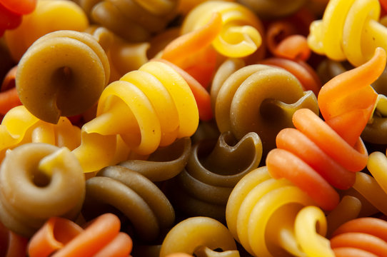 close-up of colorful raw spiral shaped pasta
