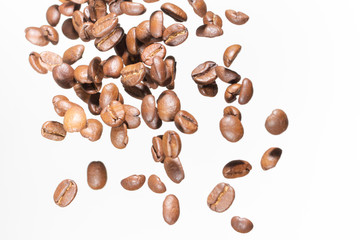 Falling coffee beans, in motion, on a white background. Selective focus.