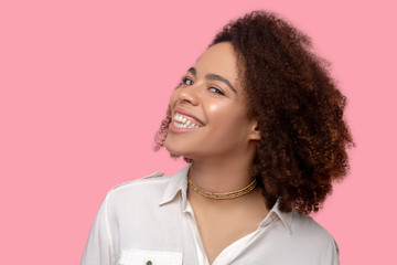 Successful and happy young woman with curly hair, white-toothed smile.