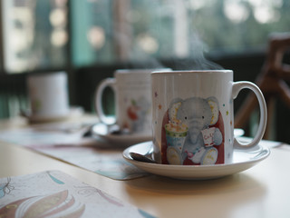 smoke on Black coffee in a white cup placed on a wooden table