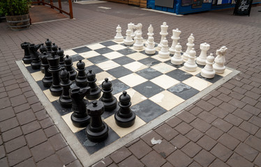 Human sized chest board in public square with white and black set of pieces
